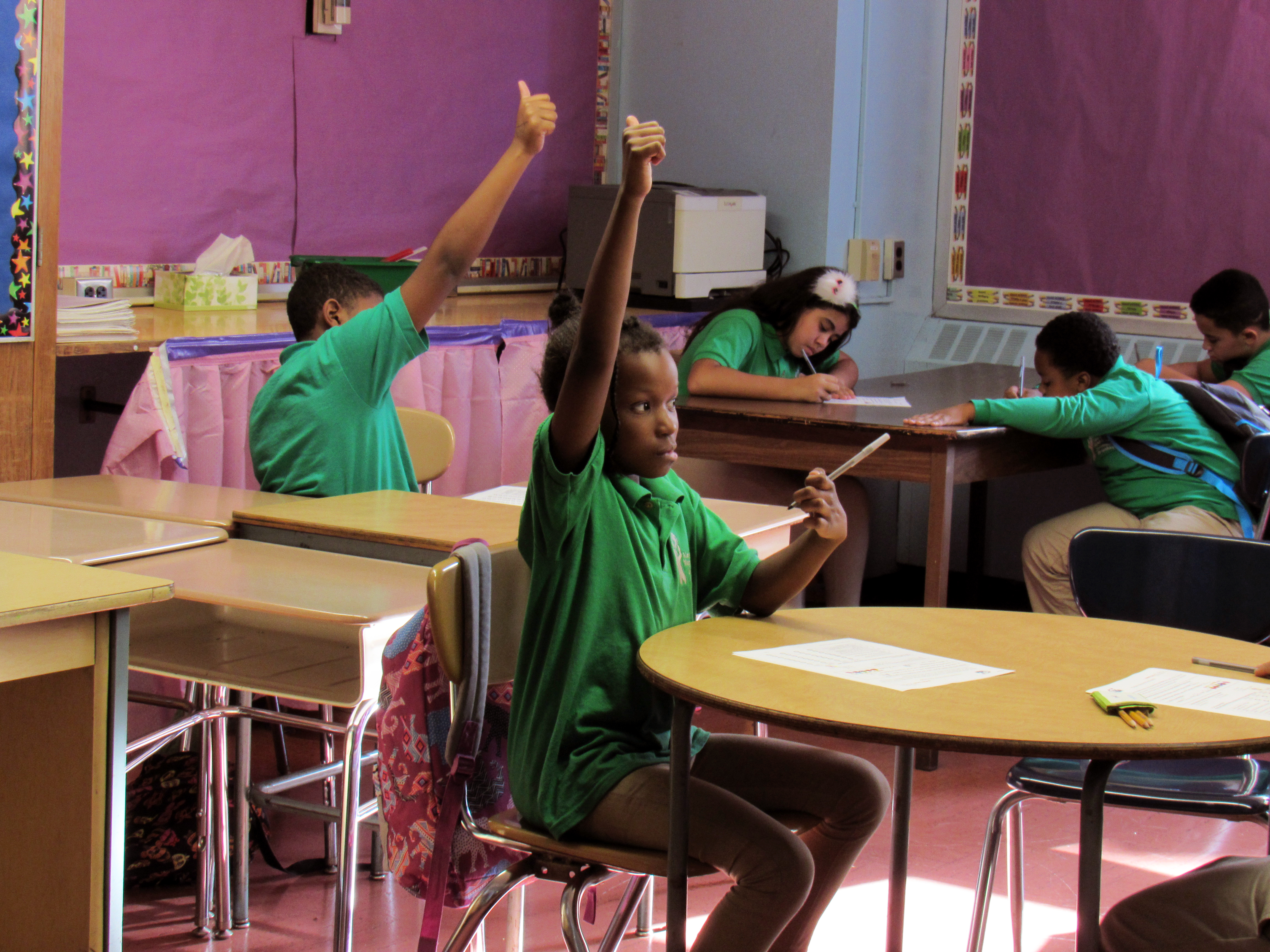 Classroom3 Children in classroom with their hand raised